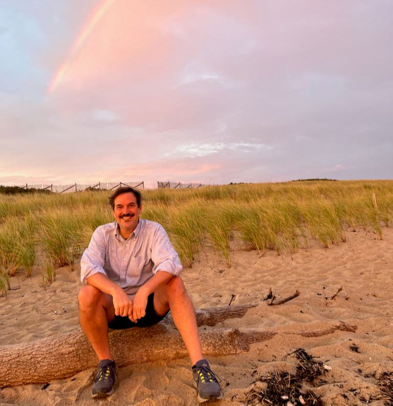 This is a photo my best friend took of me the summer of 2024 on Herring Cove Beach in Provincetown Massachusetts with a large rainbow behind me! Nature means the world to my work, both as a place and as an idea. 